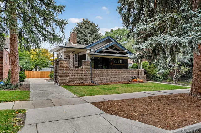 a front view of a house with a yard and trees