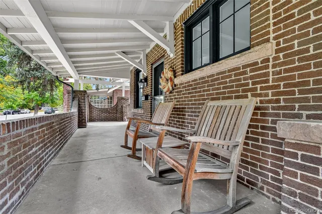 a view of a patio with table and chairs with wooden floor and fence