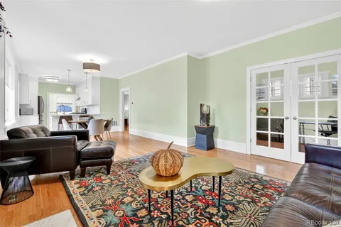 a living room with furniture a rug and kitchen view