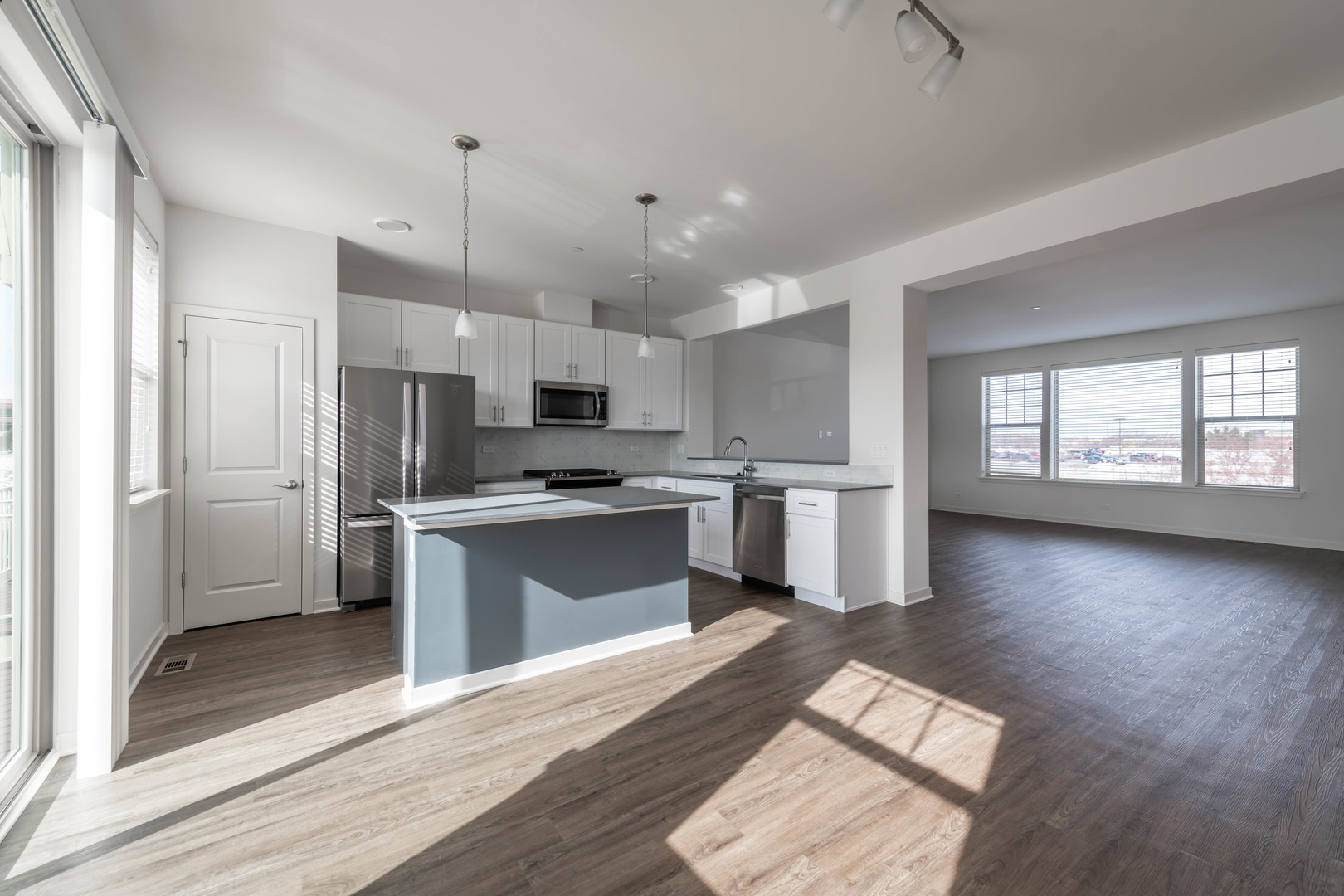 21599 West Field Court, Unit 21567 Deer Park, IL 60010 - Photo 5 of 14 a kitchen with granite countertop a refrigerator a sink dishwasher a stove and white cabinets with wooden floor
