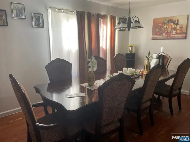 a dining room with furniture a chandelier and wooden floor