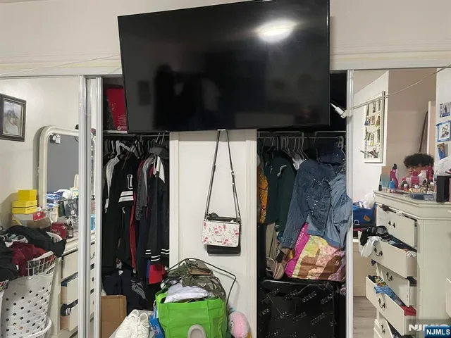 a view of walk in closet with clothes and shoes