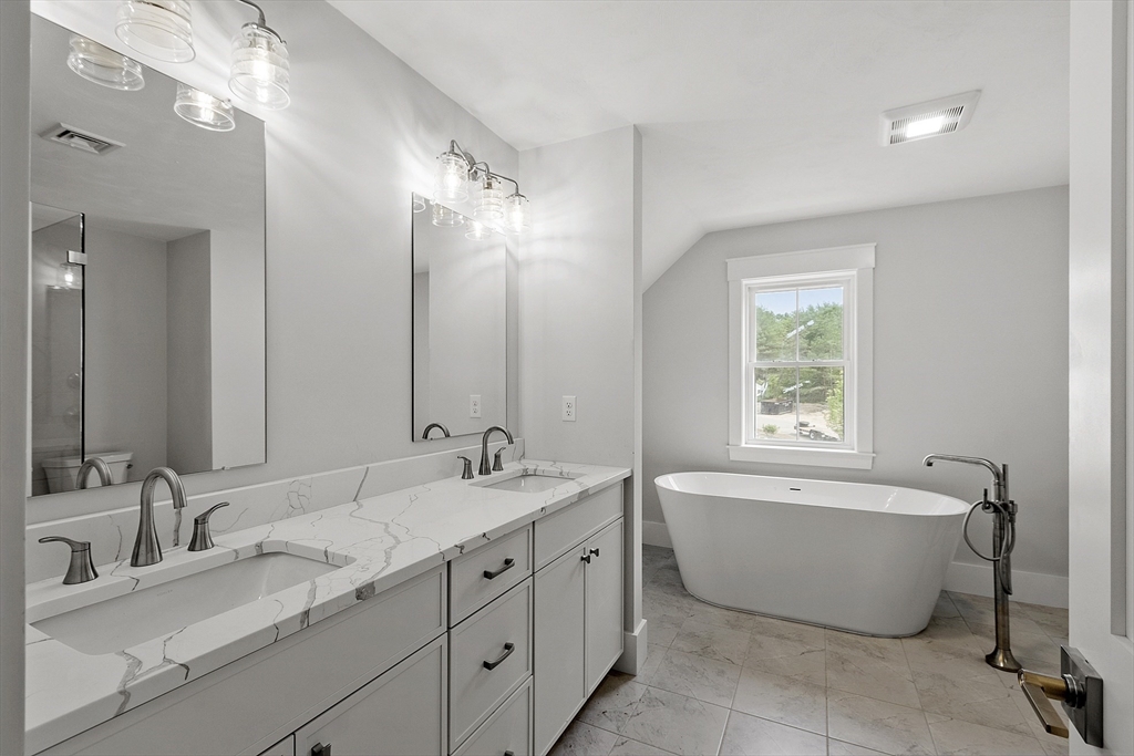 22 Waites Crossing Norfolk, MA 02056 - Photo 25 of 33 a bathroom with a tub sink double vanity granite and a mirror