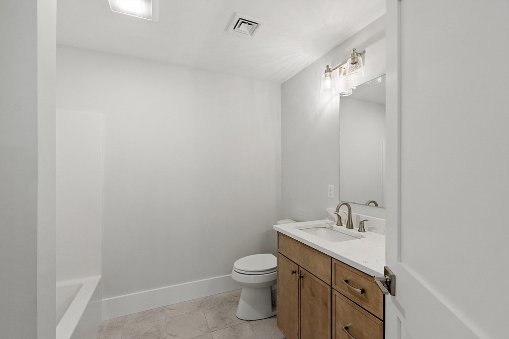 22 Waites Crossing Norfolk, MA 02056 - Photo 28 of 33 a bathroom with a granite countertop sink toilet and a mirror