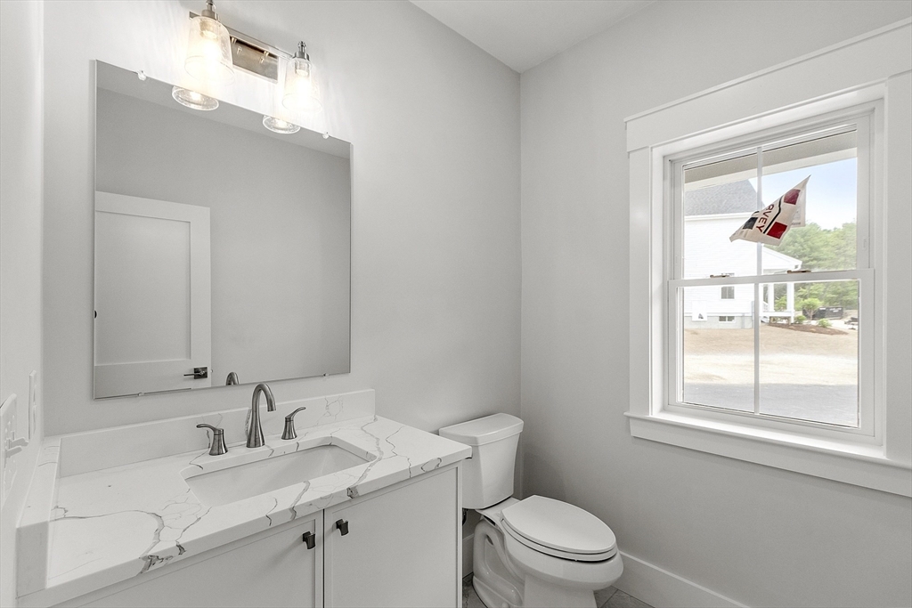 22 Waites Crossing Norfolk, MA 02056 - Photo 5 of 33 a bathroom with a granite countertop sink a toilet and a window