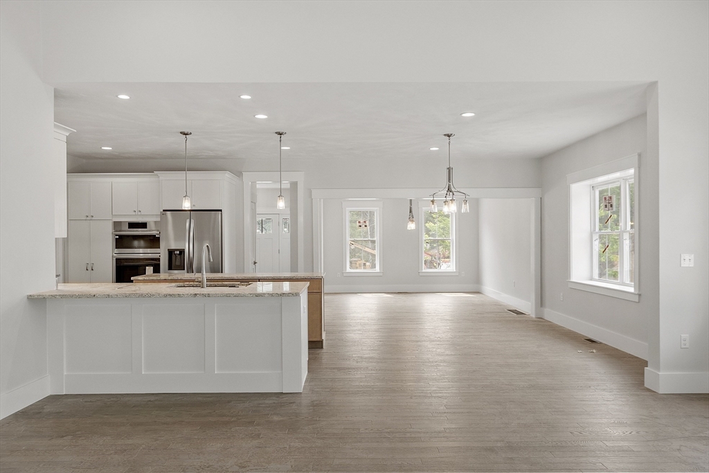 22 Waites Crossing Norfolk, MA 02056 - Photo 8 of 33 a large kitchen with stainless steel appliances kitchen island a large counter top and a wooden floor
