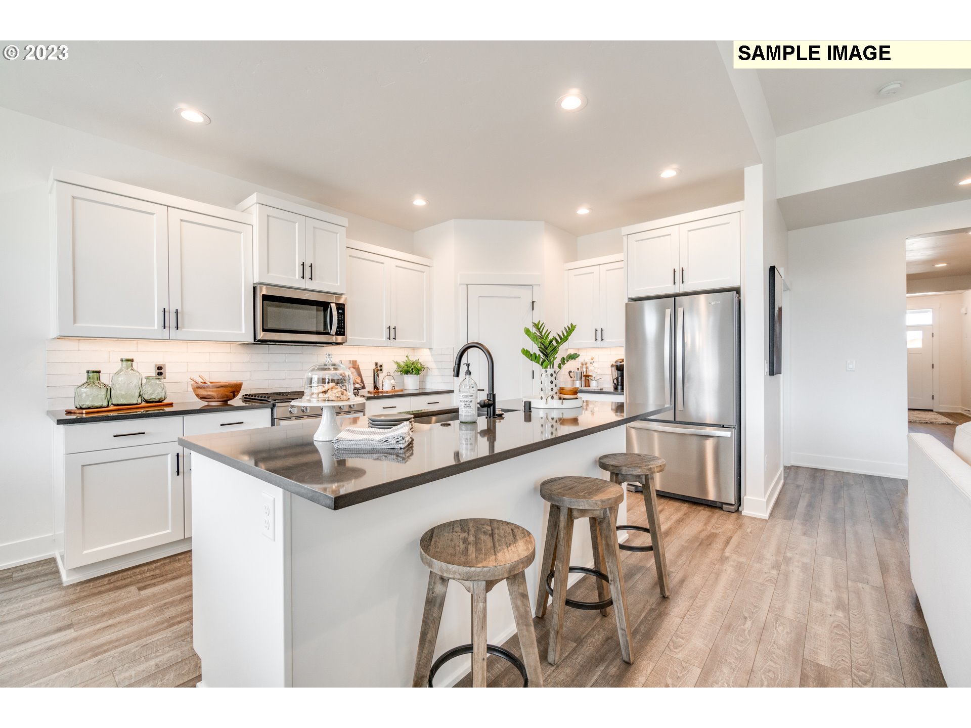 3616 South Arwana Lane Ridgefield, WA 98642 - Photo 4 of 8 a kitchen with white cabinets and stainless steel appliances