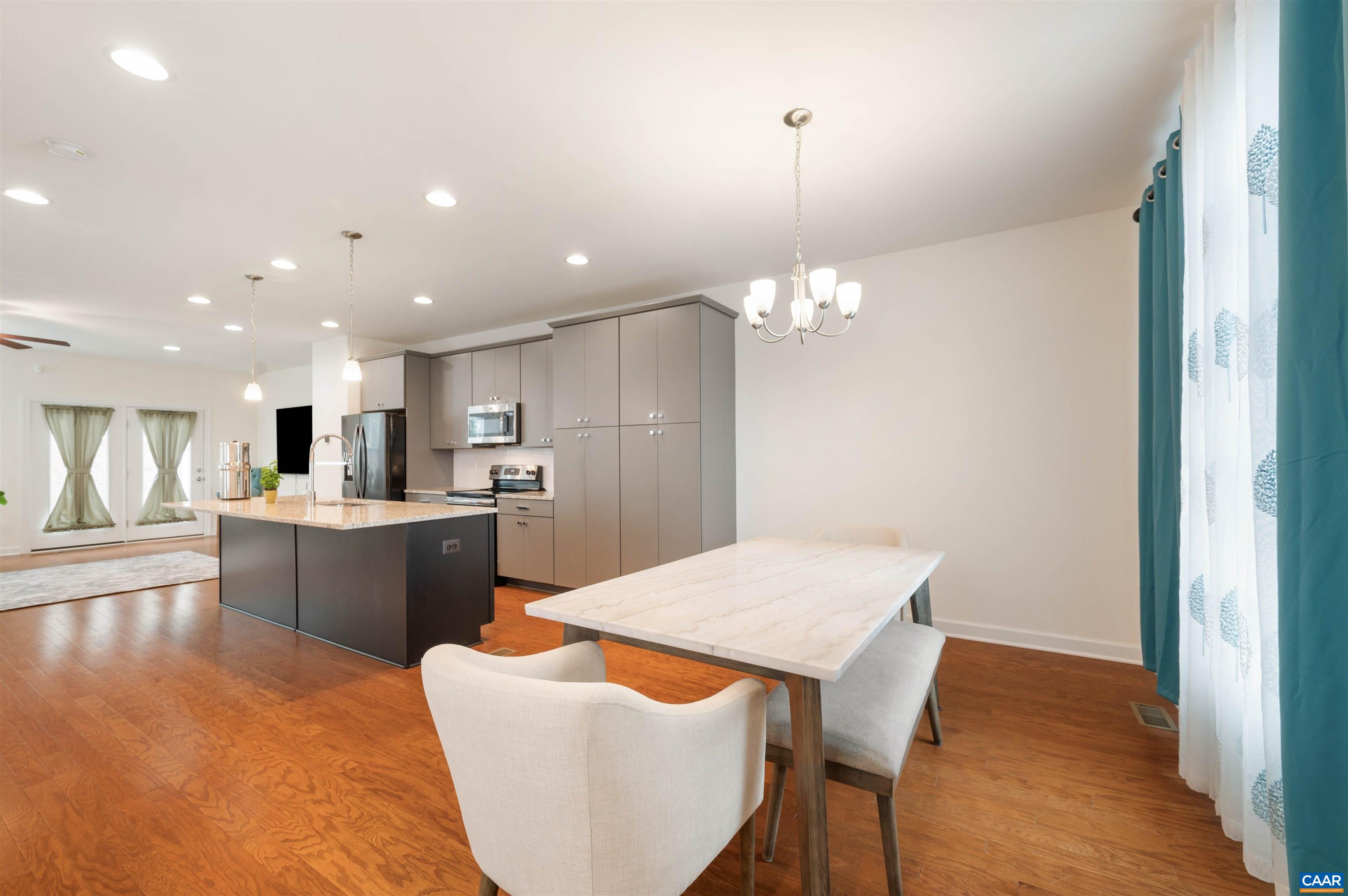 1670 Delphi Drive Charlottesville, VA 22911 - Photo 16 of 47 a kitchen with a dining table chairs wooden floor cabinets and appliances