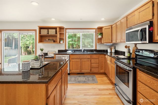 a kitchen with stainless steel appliances granite countertop a sink and stove