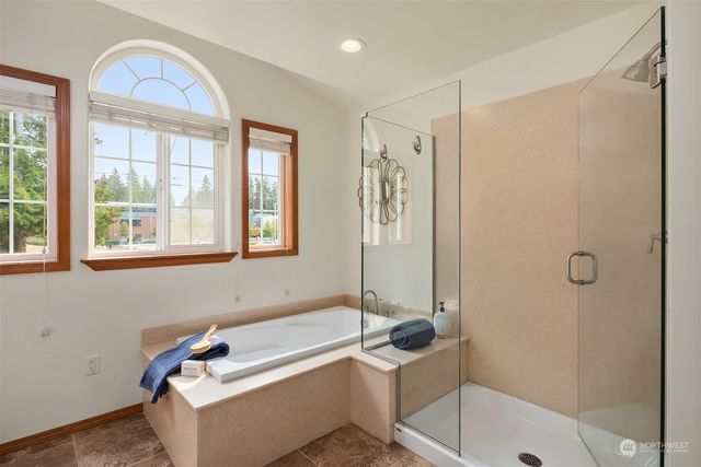 a bathroom with a tub a sink and a window