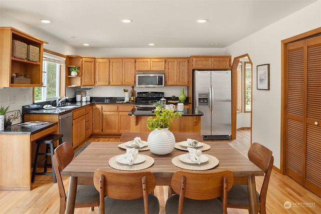 a view of a dining room with furniture a kitchen and chandelier