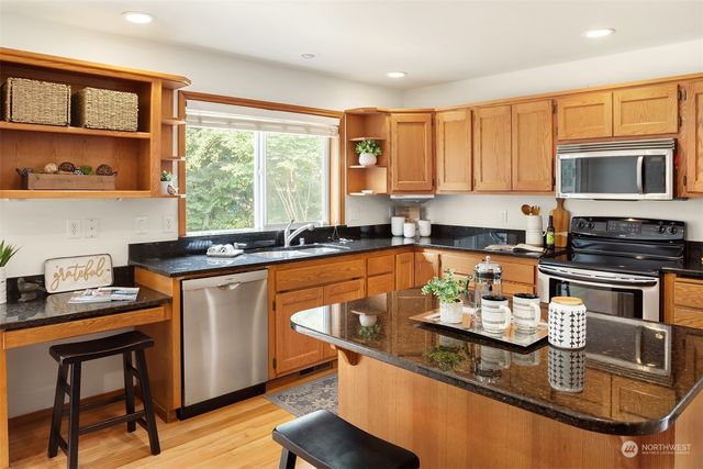 a kitchen with stainless steel appliances granite countertop a sink stove and cabinets
