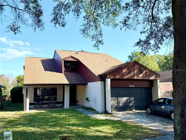 a front view of a house with a garden and sitting area