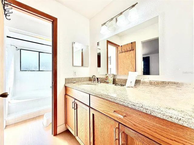 a bathroom with a granite countertop sink and a mirror