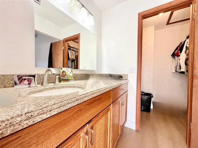 a en suite bathroom with a granite countertop sink and a mirror