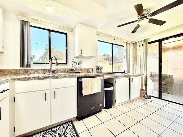 a kitchen with a sink appliances cabinets and a large window