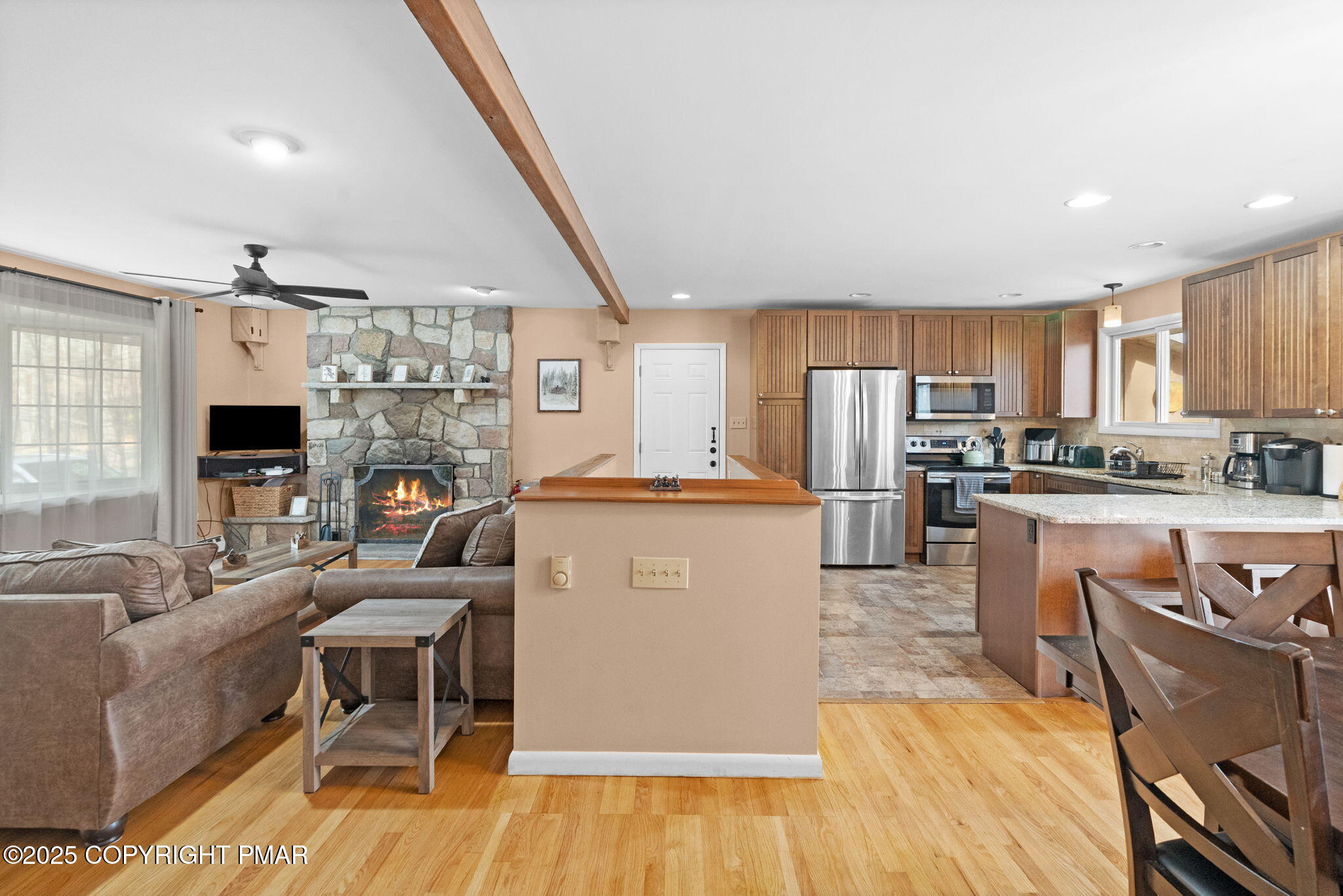 128 Winding Hill Road Pocono Pines, PA 18350 - Photo 13 of 77 a living room with stainless steel appliances a dining table wooden floor windows and a kitchen view