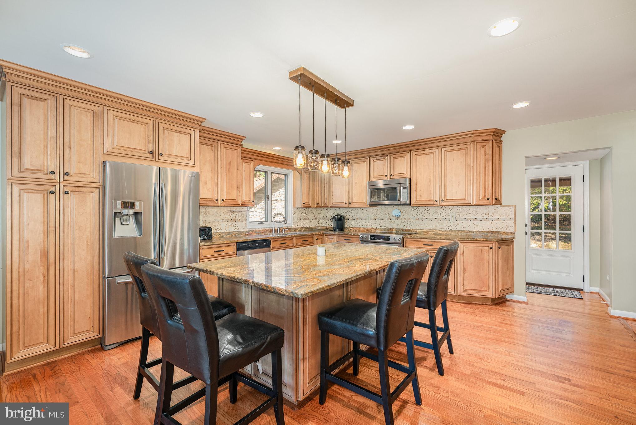 3827 Justin Road Monkton, MD 21111 - Photo 12 of 51 a kitchen with stainless steel appliances granite countertop a dining table chairs refrigerator and cabinets