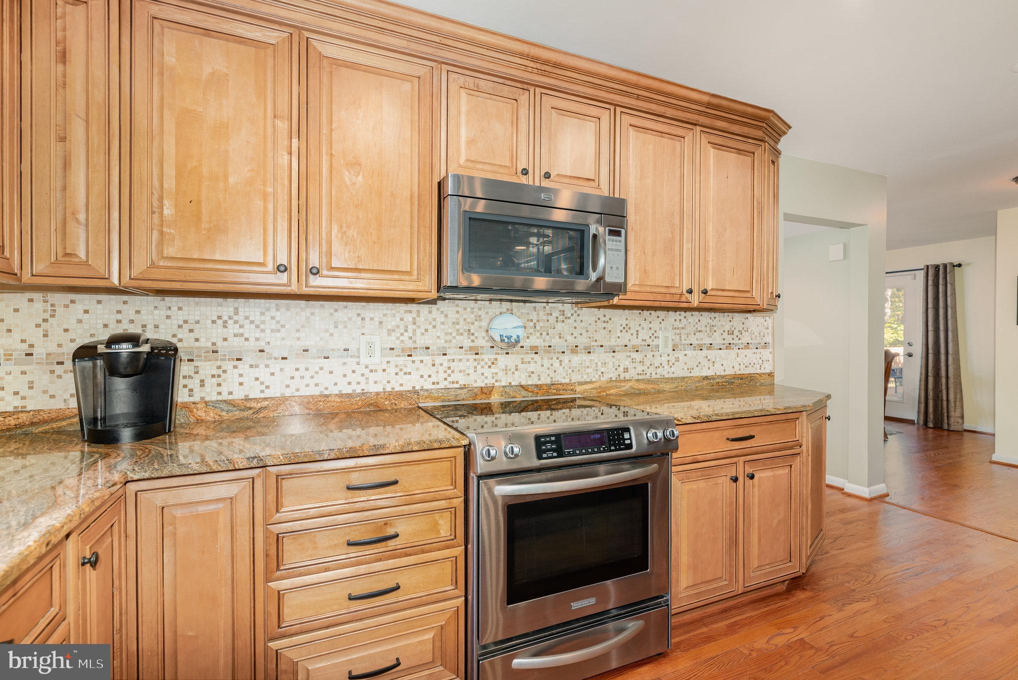 3827 Justin Road Monkton, MD 21111 - Photo 13 of 51 a kitchen with granite countertop a stove top oven microwave and cabinets