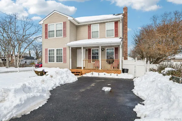 a view of a white house with a yard covered in snow