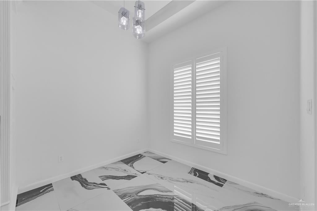 1315 Thompson Road Mission, TX 78573 - Photo 12 of 38 Unfurnished room featuring marble look tile flooring and a chandelier