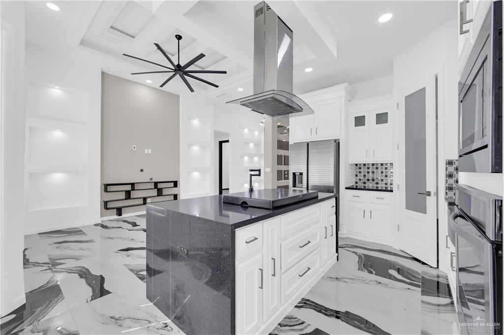 1315 Thompson Road Mission, TX 78573 - Photo 13 of 38 Kitchen featuring recessed lighting, light marble finish flooring, island range hood, stainless steel appliances, and dark stone countertops