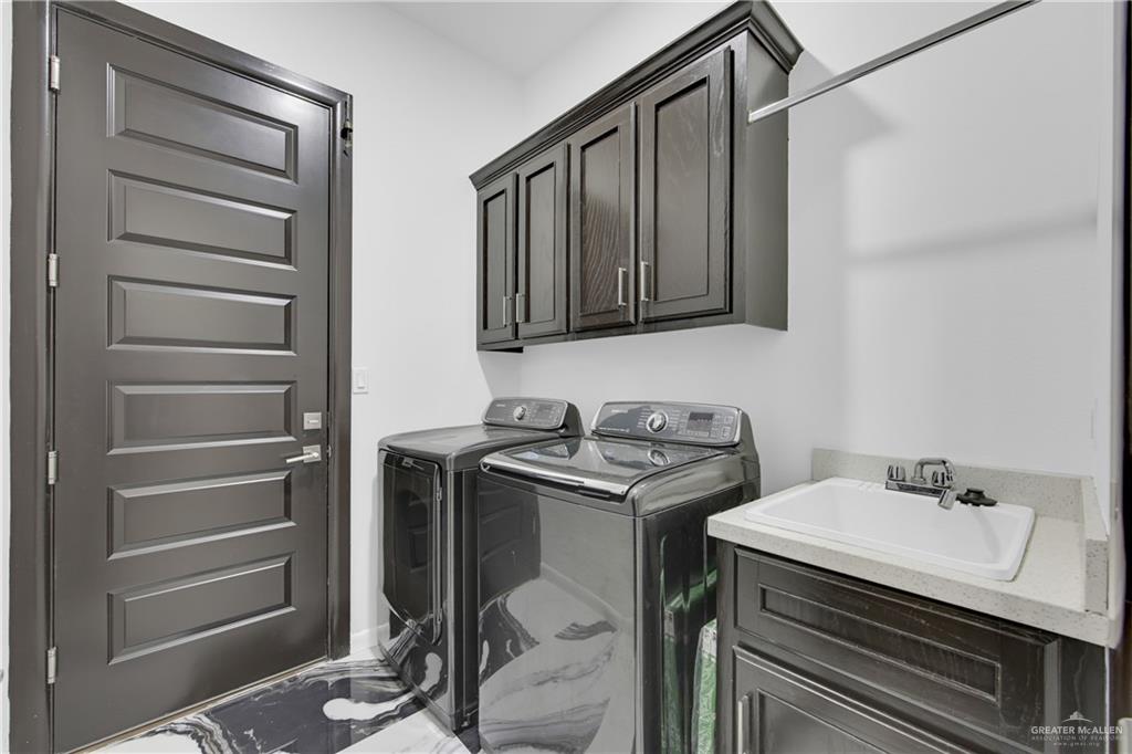 1315 Thompson Road Mission, TX 78573 - Photo 16 of 38 Washroom featuring cabinet space, washing machine and dryer, and marble look tile flooring