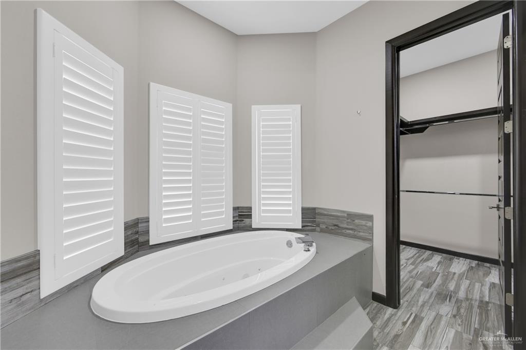 1315 Thompson Road Mission, TX 78573 - Photo 21 of 38 Full bath with a whirlpool tub, a walk in closet, and light wood finished floors