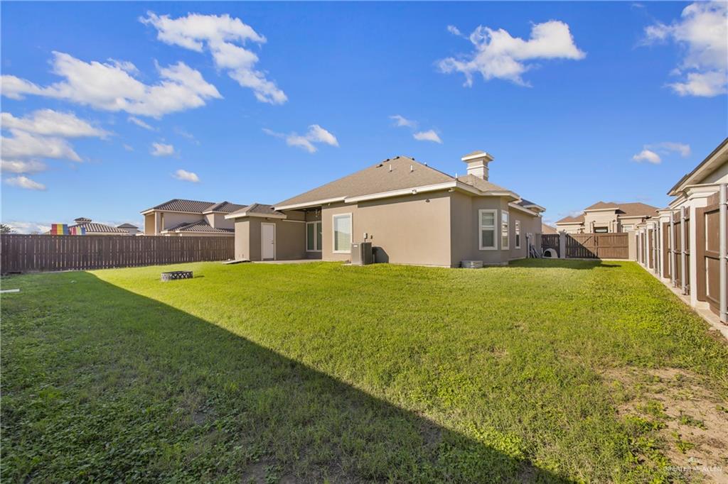 1315 Thompson Road Mission, TX 78573 - Photo 29 of 38 Back of house with a fenced backyard, a chimney, and stucco siding