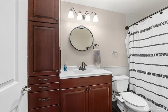a bathroom with a toilet a sink and a mirror