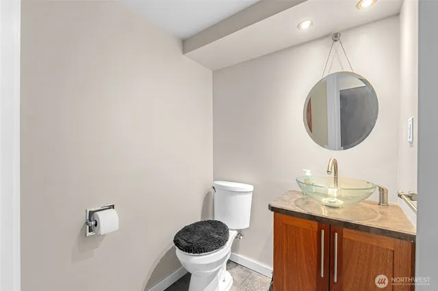 a bathroom with a granite countertop sink a mirror and a toilet