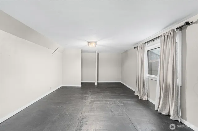 an empty room with a ceiling fan and window