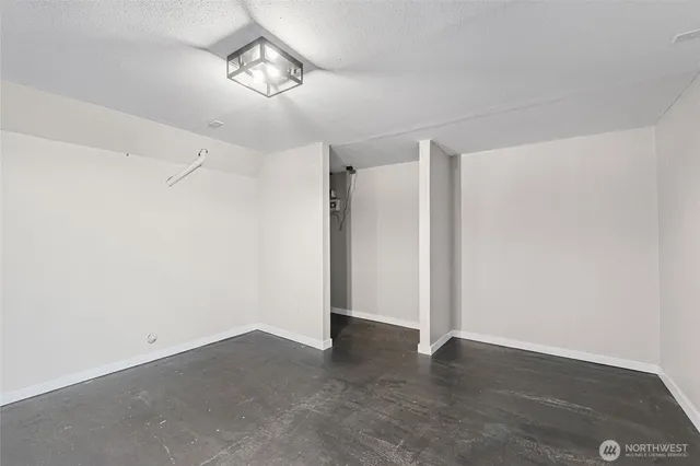 a view of an empty room with chandelier fan