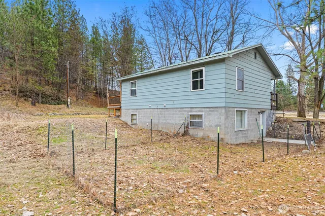a view of a white house with a yard and sitting area