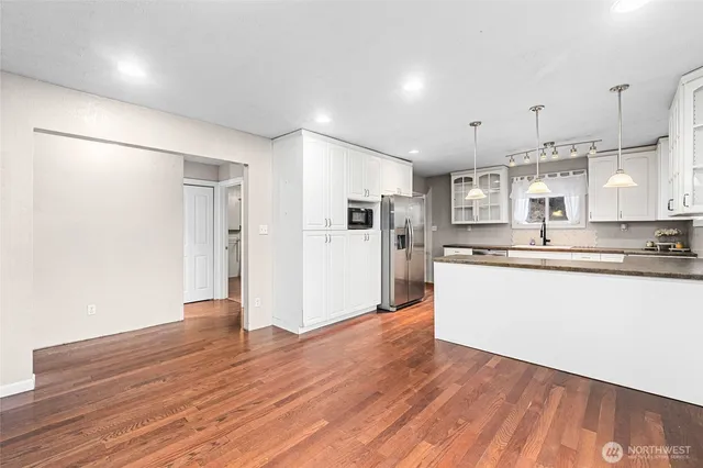 a view of a kitchen with stainless steel appliances granite countertop a refrigerator and a stove top oven