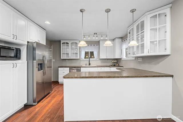 a kitchen with stainless steel appliances granite countertop a sink a stove and refrigerator