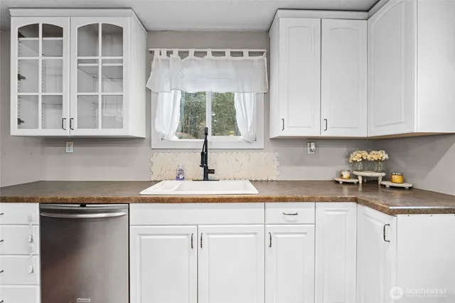 a kitchen with stainless steel appliances granite countertop a sink and a white cabinets