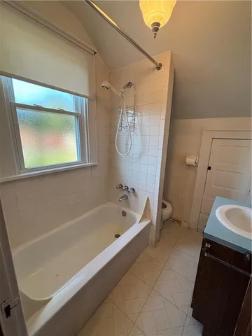 a bathroom with a tub a sink and a shower