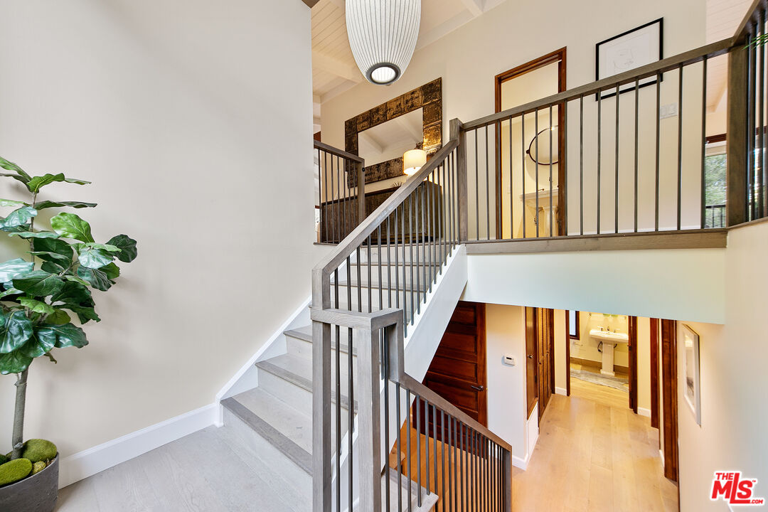 25659 Aline Way Calabasas, CA 91302 - Photo 24 of 53 a view of staircase with lots of frames on wall and a potted plant