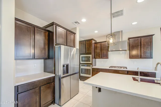 a kitchen with stainless steel appliances kitchen island granite countertop a sink and cabinets