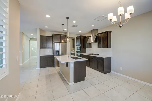 a kitchen with stainless steel appliances granite countertop a sink a stove and a refrigerator
