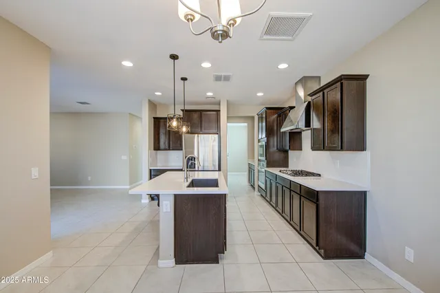 a kitchen that has a sink a center island stainless steel appliances and cabinets