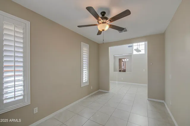 a view of an empty room with window and chandelier