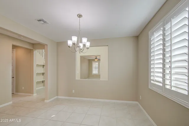 a view of empty room with ceiling fan and window