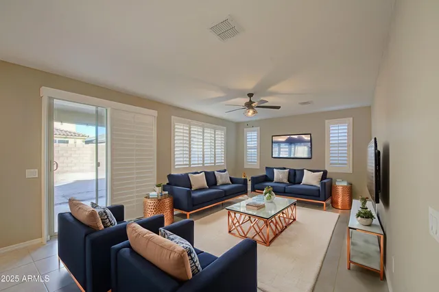 a living room with furniture a ceiling fan and a window