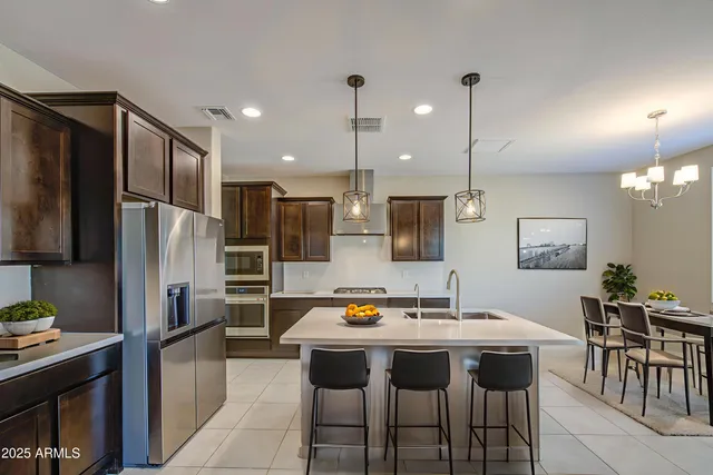 a kitchen with stainless steel appliances granite countertop a sink refrigerator and cabinets