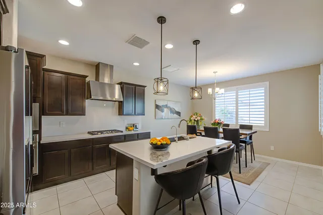 a kitchen that has a sink a table and chairs in it