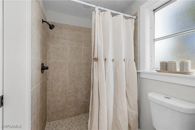 a kitchen with stainless steel appliances a refrigerator a sink dishwasher a stove and a dining table with wooden floor