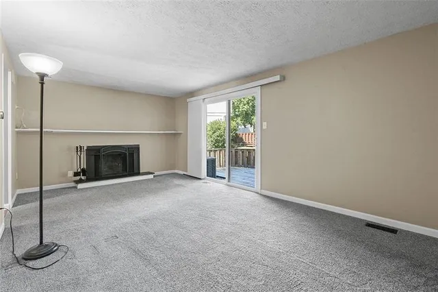a view of empty room with fireplace and fan