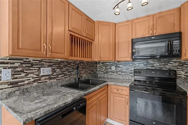 a kitchen with stainless steel appliances granite countertop a sink stove and microwave
